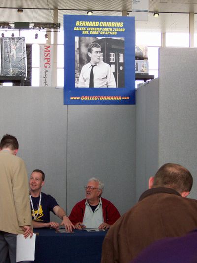 Bernard Cribbins sitting underneath his poster
