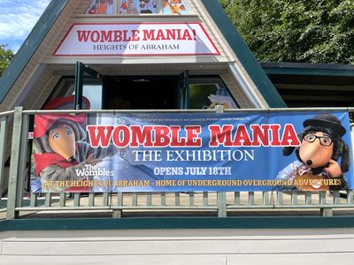 Banner in front of the pavilion saying 'Womble Mania The Exhibition opens July 18th'