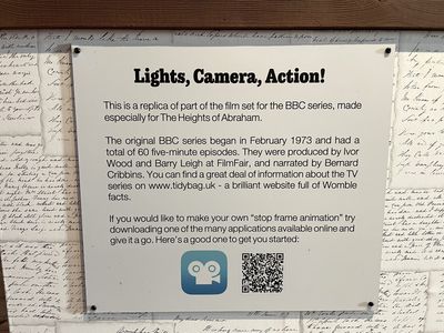 Sign titled 'Lights, Camera, Action!' saying this is a replica of part of the film set, and explaining how the BBC series was made. The sign also says: 'You can find a great deal of information about the TV series on www.tidybag.uk - a brilliant website full of Womble facts.'