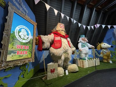 Wombles today, with a screen showing the 'Be more Womble' logo with the text 'We're back'